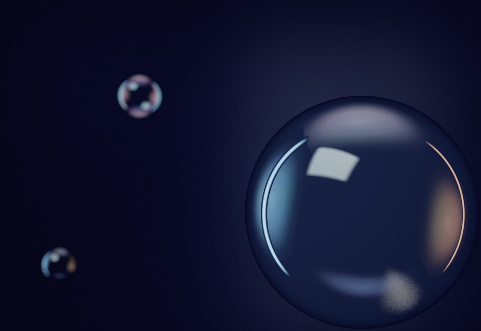 A large clear glass sphere close to the lens on the right, its edge carrying cyan and warm reflections.